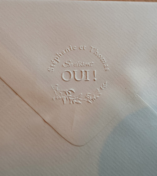 Embossage des faire-parts de mariage avec une pince personnalisée.