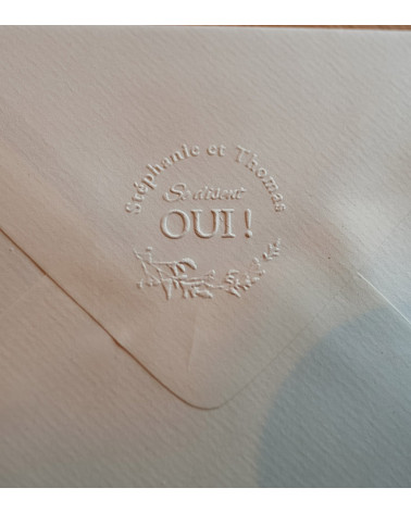 Embossage des faire-parts de mariage avec une pince personnalisée.